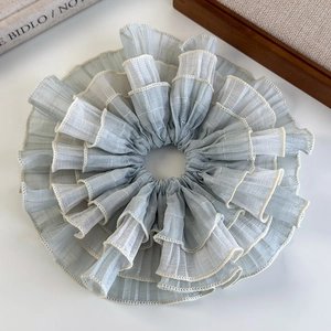 Detail of light blue layered organza scrunchie with cream scalloped lace edges