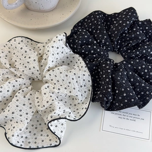 Dettaglio di grandi elastici scrunchie in seersucker con stelle e bordo overlock curato