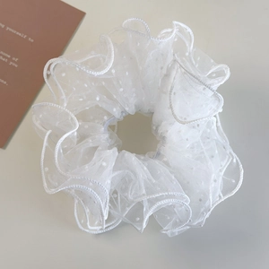 Detailed view of white mesh polka dot scrunchie with soft ruffled texture and sheer fabric