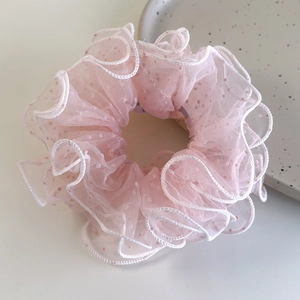 Detailed view of pink polka dot mesh hair scrunchie with delicate white lettuce edges