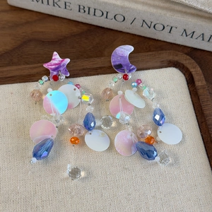 Detail view of asymmetric celestial earrings with colorful beads and star moon charms