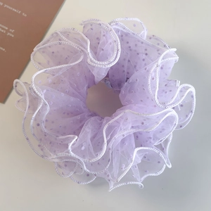 Macro shot of light purple mesh scrunchie with polka dots and white wavy edges