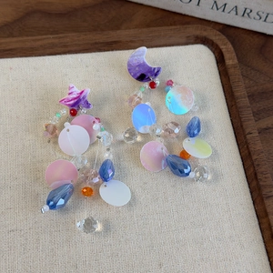 Detail of beaded star and moon earrings with colorful sequins and crystal droplets
