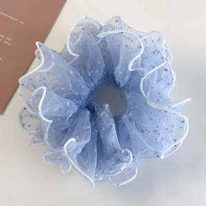 Close-up of light blue mesh scrunchie with white polka dots and delicate wavy edges