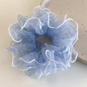 Close-up of light blue mesh scrunchie with white scalloped edges and fine polka dots