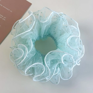 Detail of light green mesh scrunchie with flocking dots and white scalloped edges