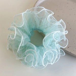 Detail of mint green mesh hair scrunchie with polka dots and delicate white ruffled edges