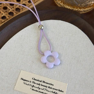 Detalle del collar de flores lavanda con cordón violeta ajustable en bandeja de madera