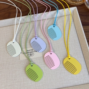 Colorful comb-shaped pendant necklaces in pastel matte finishes with matching cords