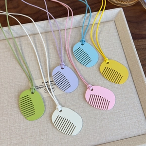 Detail view of colorful comb pendants in six pastel colors on matching leather cords