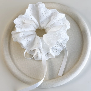 Detail of white four-layer lace scrunchie with floral embroidery and long ribbon