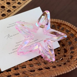 Close-up of star-shaped aurora acrylic hair claw with shiny translucent pink finish