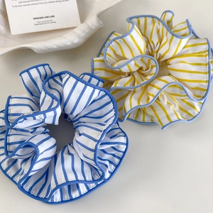 Detailaufnahme der blau und gelb gestreiften Oversize-Haargummis mit feiner Kante