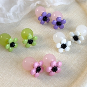 Chic resin flower earrings set in four pastel colors on textured surface
