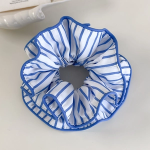 Detailansicht eines blau-weiß gestreiften Stoff-Scrunchies mit dunkelblauem Saum