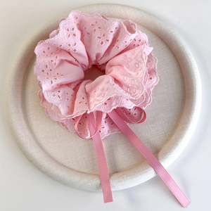 Detail view of pink cotton lace scrunchie with floral embroidery and long ribbon