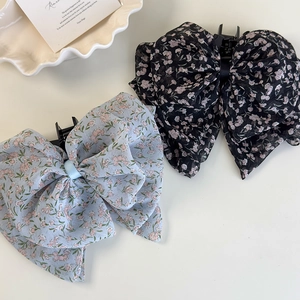 Haarklammern mit floralen Chiffon-Schleifen in Schwarz und Blau auf hellem Hintergrund