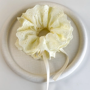 Detail of light beige Anglaise lace hair scrunchie with long ribbons and scalloped edges