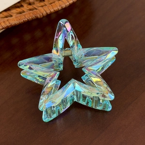 Macro shot of iridescent hollow star hair claw with colorful laser metallic finish