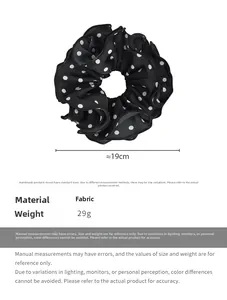 Detail view of a 19cm large black and white polka dot fabric scrunchie with ruffled edges