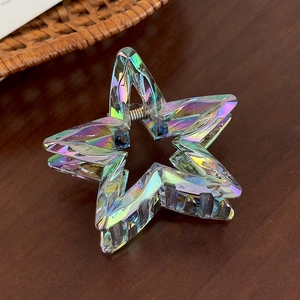 Detailed close-up of iridescent star hair claw showing acrylic texture and rainbow coating