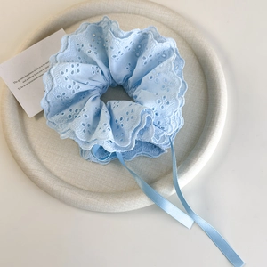 Detail of light blue lace hair scrunchie with embroidery and long silk ribbons