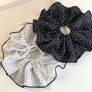 Elegante set di elastici per capelli in mesh a pois bianchi e neri su un vassoio