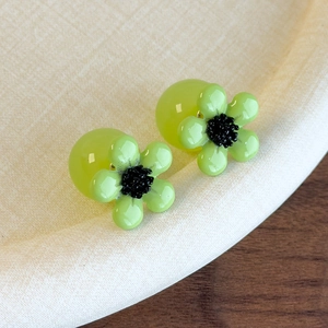Close-up of green resin flower studs with dark stamen and lime translucent sphere backings