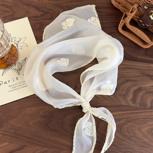 Detail of elegant French style cream headscarf with rose embroidery and lace edges