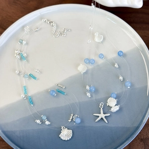 Three-strand ocean theme necklace with blue crystal beads and silver starfish charms