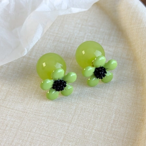 Macro shot of fresh green resin flower earrings with translucent round beads