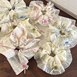 Floral fabric hair scrunchies with bow and button detail on a wooden surface
