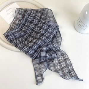 Macro detail of high-quality narrow plaid silk scarf with refined stitching and texture