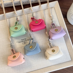 Mini porte-monnaie en cuir de six couleurs disposés dans un plateau beige