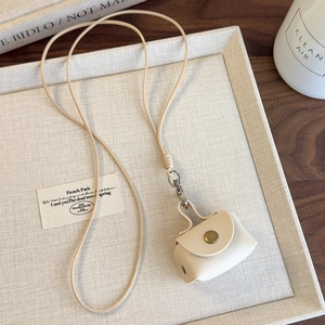 Détail d'un collier porte-monnaie en cuir PU crème avec bouton pression en métal doré