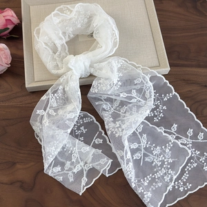 Élégante écharpe en dentelle florale blanche avec broderie et bords ondulés sur bois