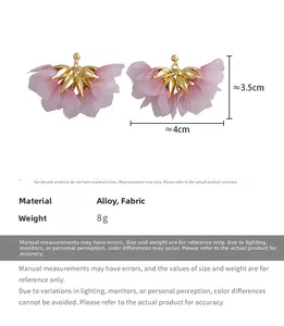 Macro detail of sweet pink gradient fabric petal earrings with golden leaf accents