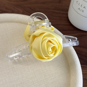 Detail of the elegant handmade yellow silk rose hair claw with transparent acrylic base