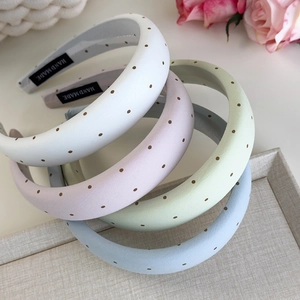 Détail de quatre serre-têtes rembourrés à pois colorés avec étiquettes faites main