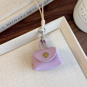 Détail du mini porte-monnaie en cuir PU violet avec finition texturée et bouton bronze