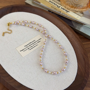 Détail du collier de perles roses synthétiques et cristaux avec chaîne dorée réglable