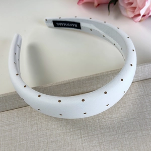 Détail d'un serre-tête rembourré blanc fait main à pois marrons avec accent floral doux
