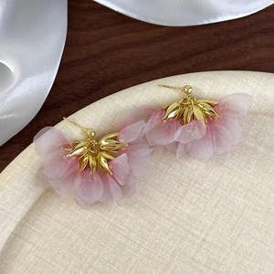 Detailed close-up of handmade pink mesh flower earrings with gold metal petals