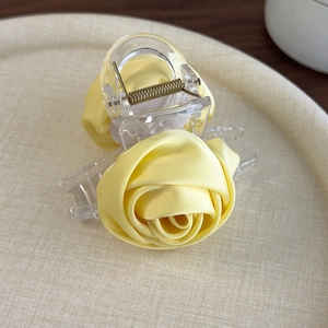 Macro detail of the yellow satin rose flower hair claw clip with transparent base