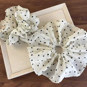 Set of two off-white heart print mesh scrunchies displayed on a cream jewelry tray
