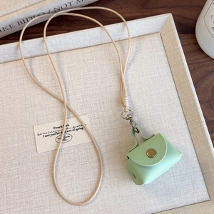 Détail de la mini pochette en cuir menthe avec bouton doré et cordon tressé ajustable