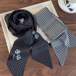 Detail of black polka dot camellia twilly scarf and checkerboard ribbon on tray