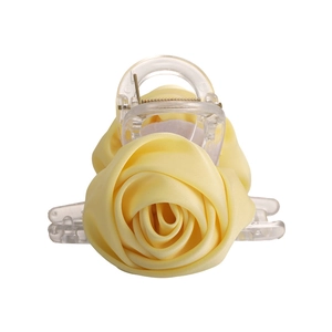Detail of elegant handmade yellow silk rose hair clip with transparent plastic claw base