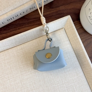 Détail d'un mini sac de cou en cuir PU bleu avec bouton pression en bronze vieilli