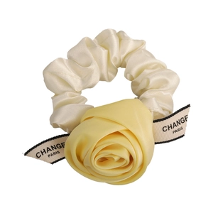 Elegant off-white satin scrunchie with a large yellow fabric rose and ribbon detail